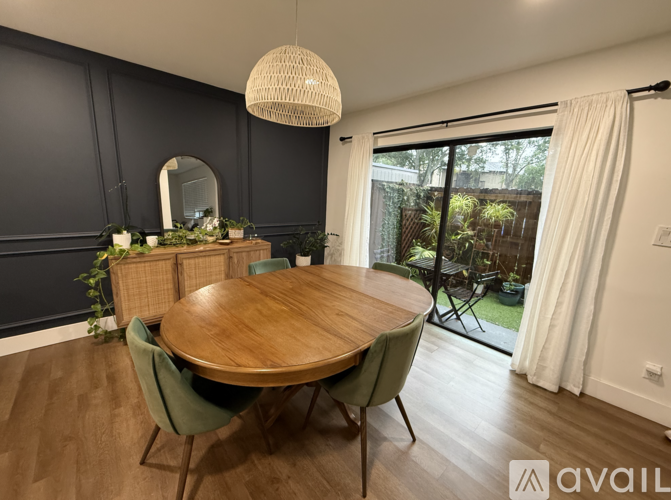 A dining room with a wooden table and green chairs.