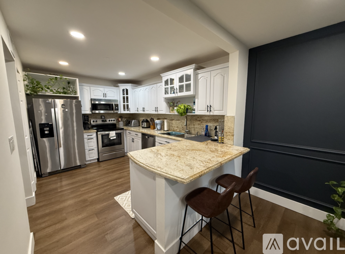 A kitchen with a marble countertop and stainless steel appliances.