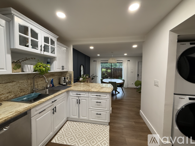 A kitchen with white cabinets and a patterned tile floor.