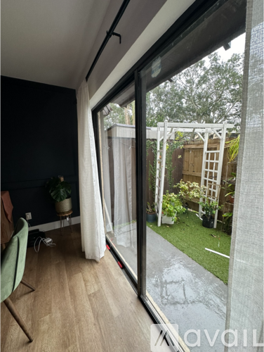 A room with a chair and a window overlooking a garden.