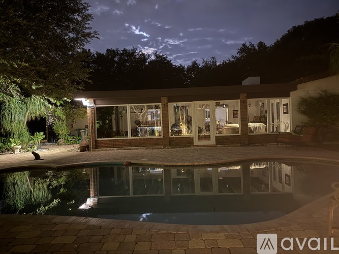 A house with a pool in front of it at night.