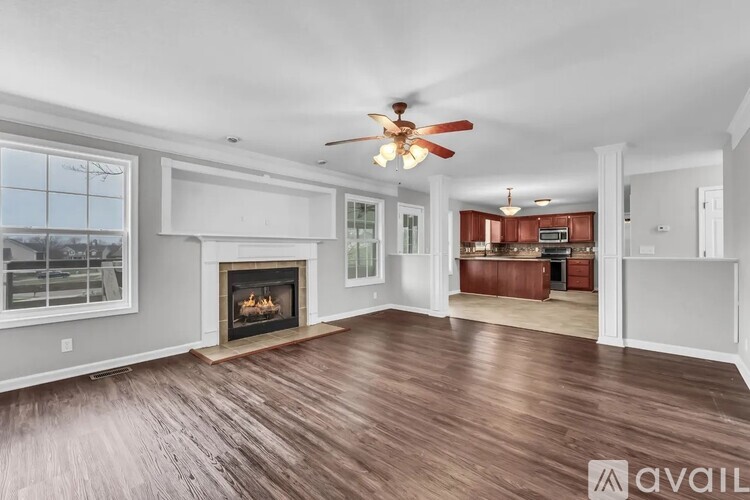 A spacious living room with wood flooring and a fireplace.