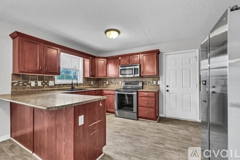 A kitchen with red cabinets and a white door.