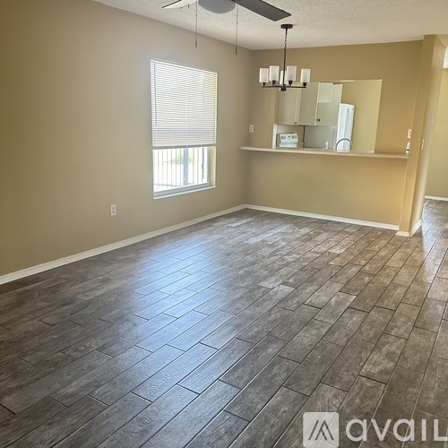 A spacious room with a ceiling fan and a large window.
