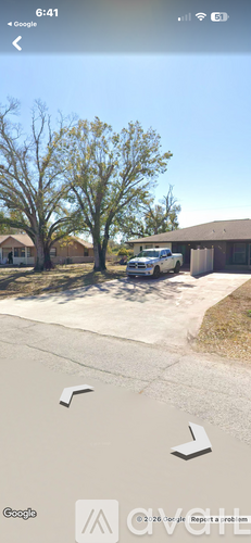 A street view of a residential area with houses and trees.