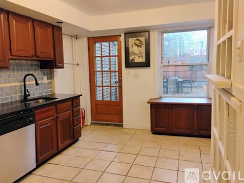 A kitchen with brown cabinets and a black counter top.