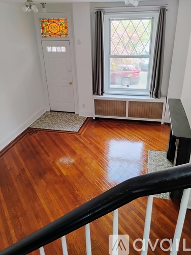 A room with wooden floors and a stained glass window.