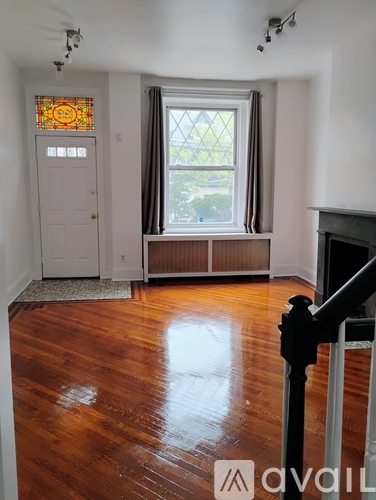 A room with a wooden floor and a stained glass window.
