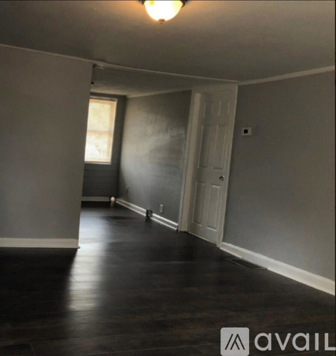 A long hallway with wood floors and white walls.