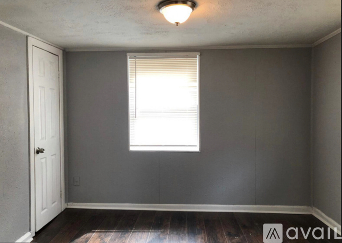 A room with a window and wooden floors.