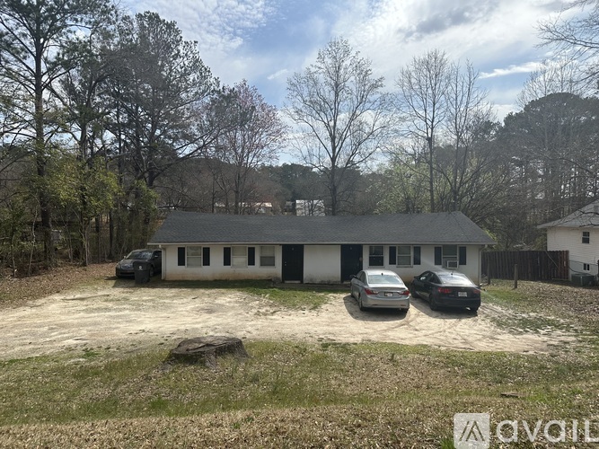 A house with a grey roof and two cars parked in front.