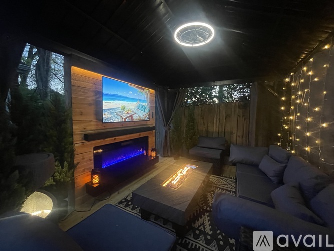 A wooden structure with a curtained entrance is situated in a backyard.