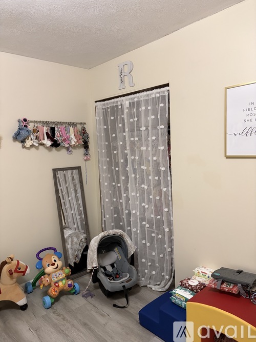A baby's room with a crib, toys, and a picture frame on the wall.