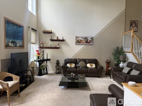 A living room with a brown couch and a television.