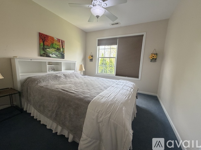 A bedroom with a large bed and a painting on the wall.
