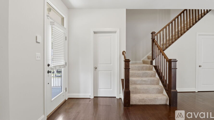 A hallway with a staircase and a door.