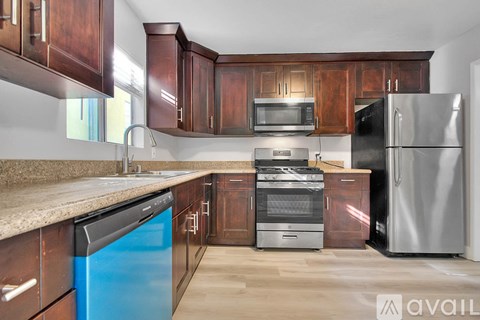 A kitchen with wooden cabinets and a blue dishwasher.