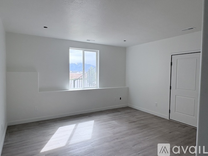 A room with a window and a door is available for rent.