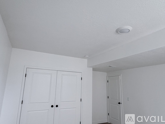 A white room with a door and a ceiling light.