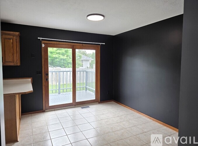 A room with a sliding glass door leading to a backyard.