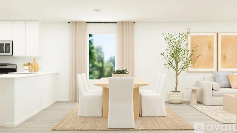 A modern living room with white furniture and a large window.