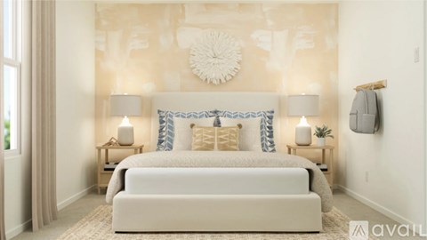 A bedroom with a large bed and a wall hanging.