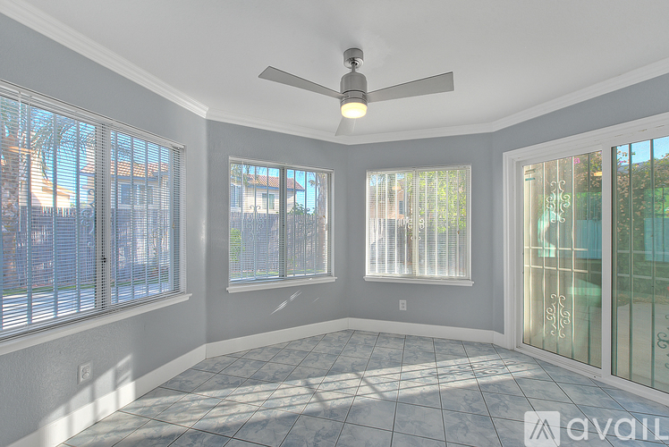 A sunny room with a fan and large windows.