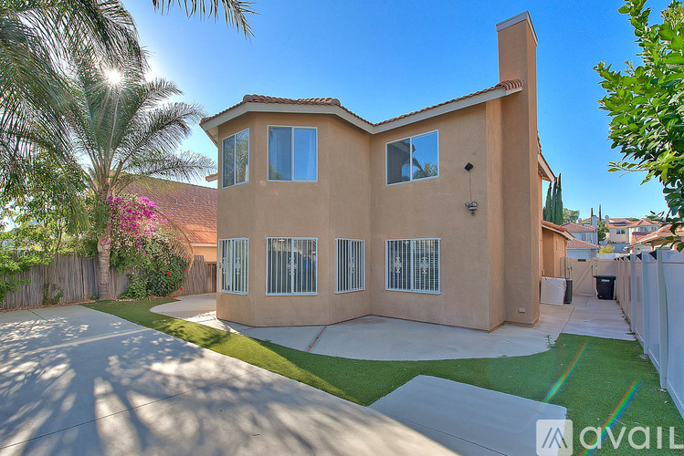 A house with a beige exterior and a green lawn in front.