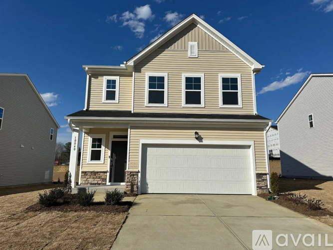 A two-story house with a garage is available for sale.
