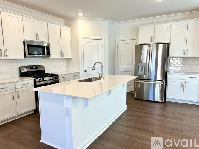 A kitchen with white cabinets and a white island.