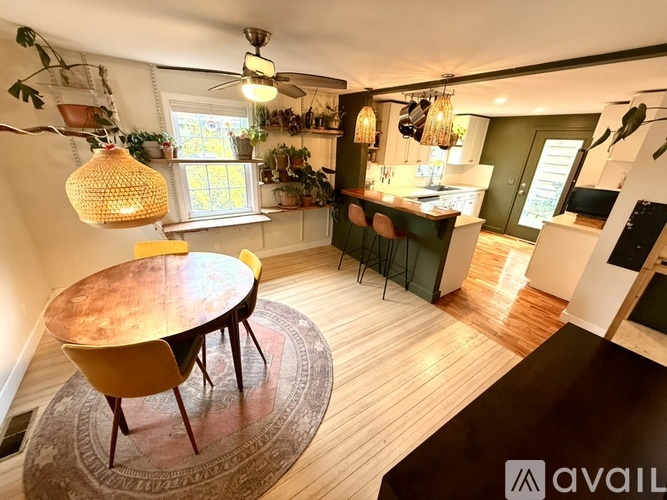 A modern kitchen with a round wooden table and yellow chairs.