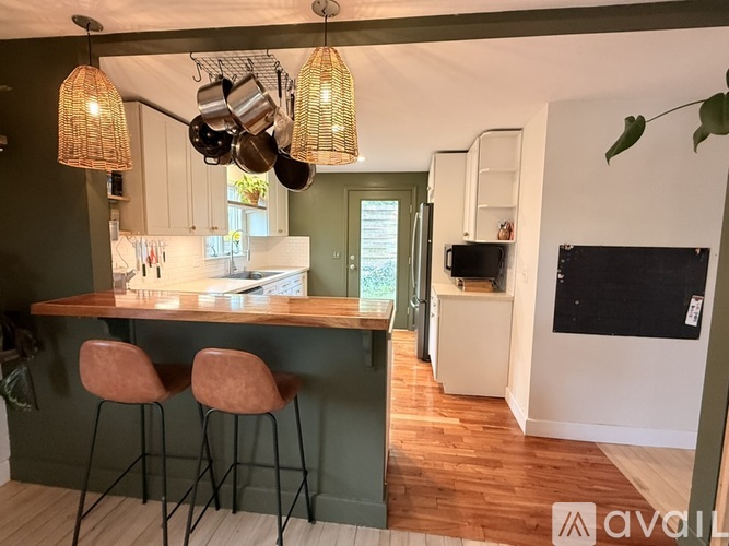 A kitchen with a bar area and two stools.
