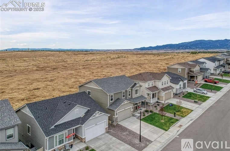 A row of houses with a mountain range in the distance.