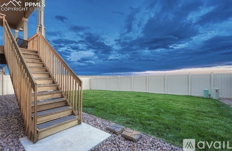 A wooden staircase with a railing leads up to a balcony.