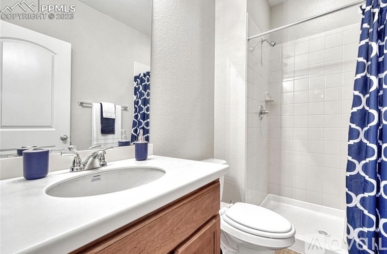 A bathroom with a white sink and a white toilet.