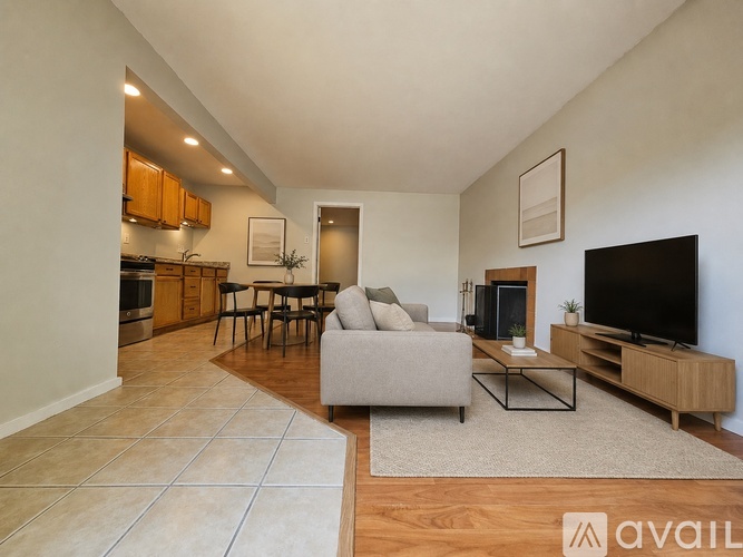 A living room with a grey couch, a black television, and a wooden cabinet.