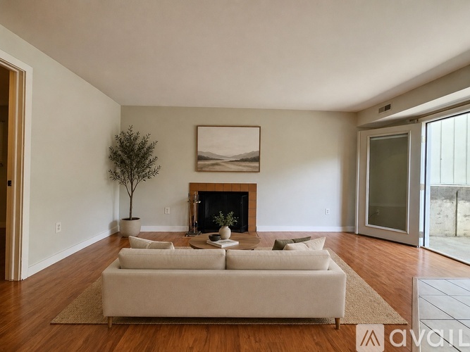 A living room with a white couch and a fireplace.