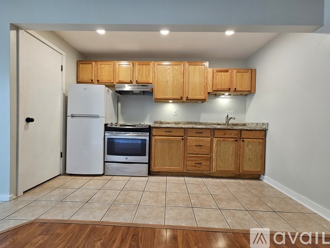 A kitchen with wooden cabinets and a white refrigerator.