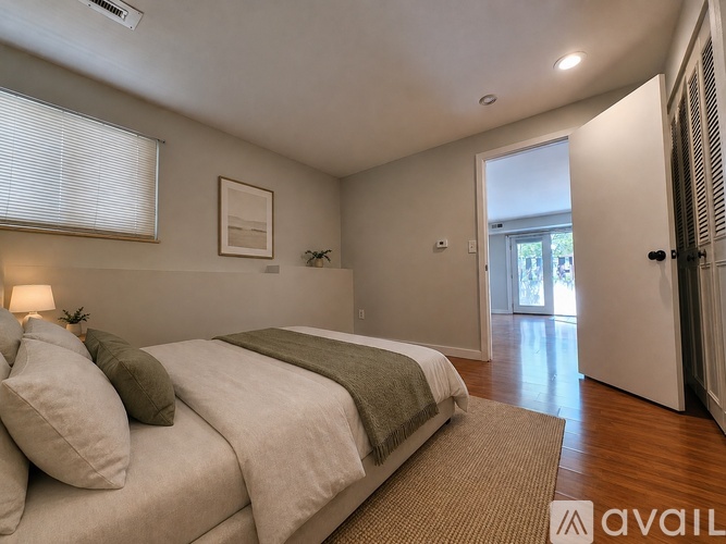 A bedroom with a bed, pillows, and a window.