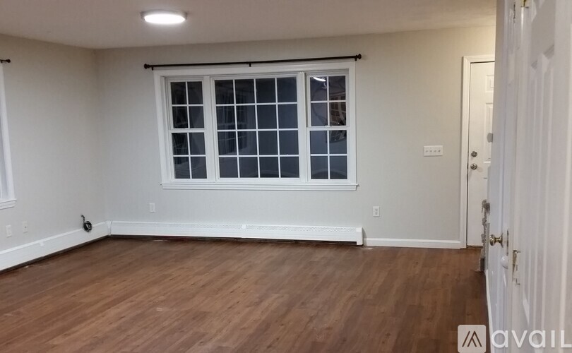 A room with a window and wooden flooring.