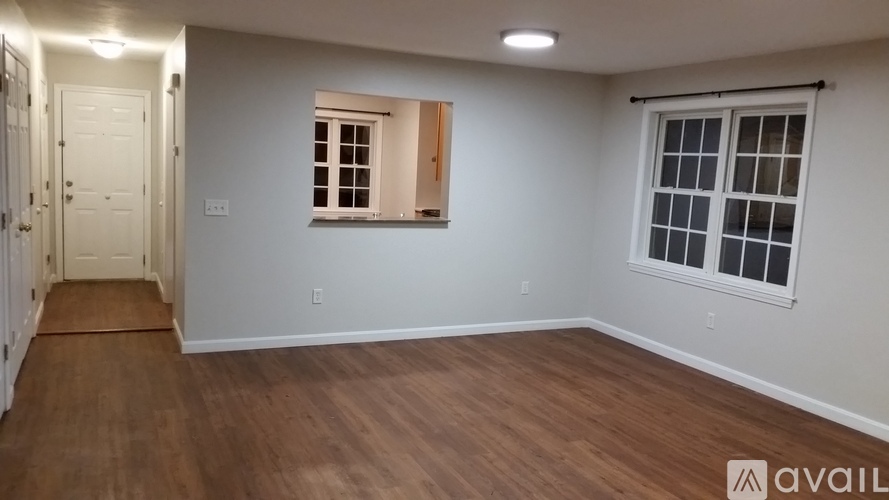 A room with wooden flooring and a window with a wooden frame.