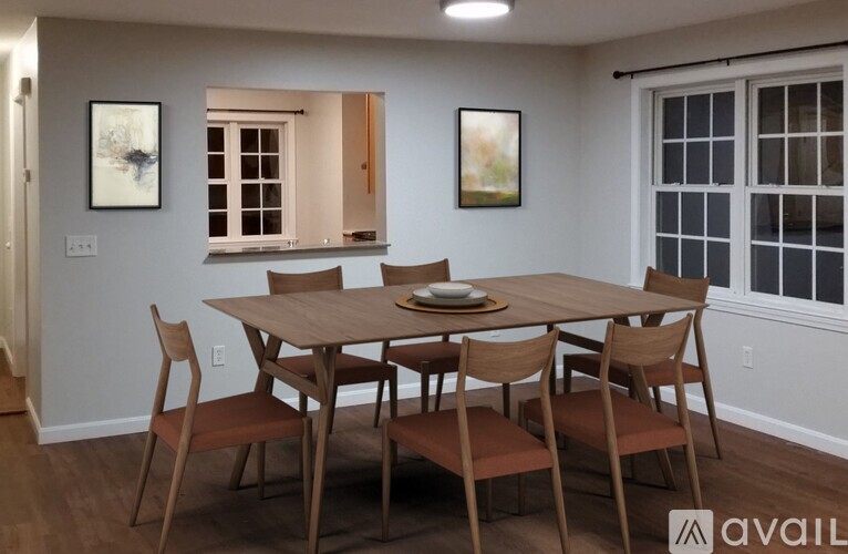 A dining room with a table and chairs.