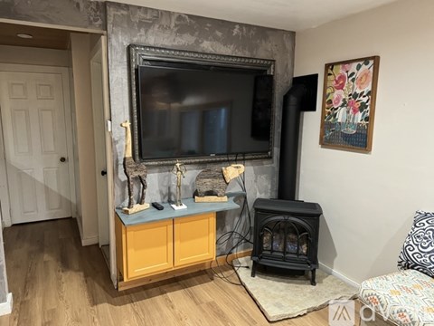 A living room with a fireplace and a television mounted on the wall.