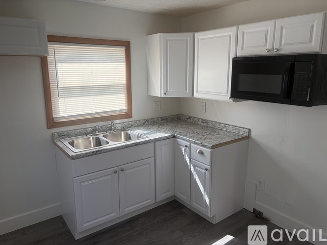 A kitchen with white cabinets and a granite countertop.