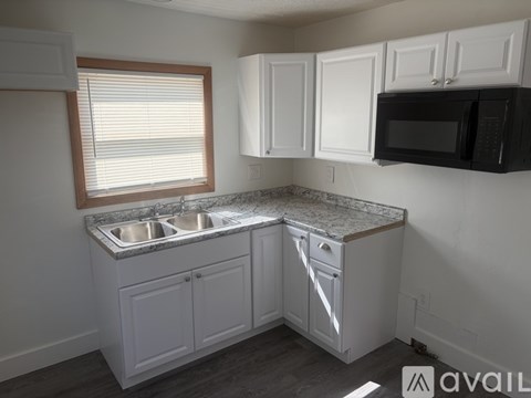 A kitchen with white cabinets and a granite countertop.