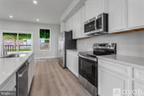 A kitchen with white cabinets and stainless steel appliances.