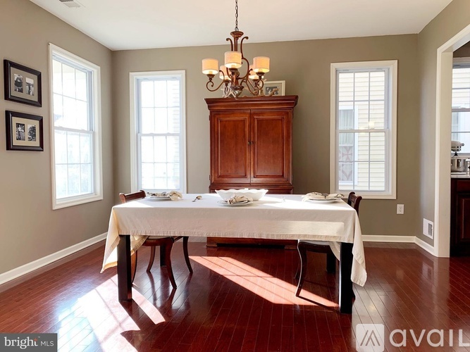 A dining room with a wooden table and chairs.