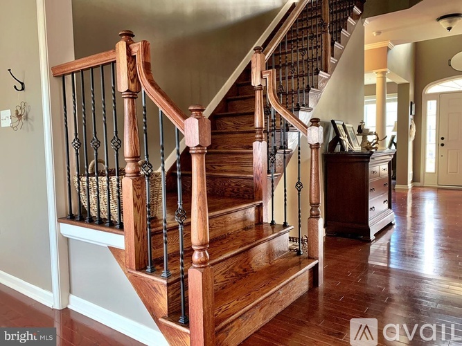 A wooden staircase with a black railing.