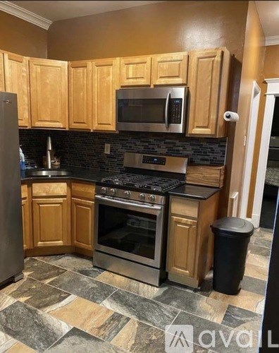 A kitchen with wooden cabinets and black countertops.