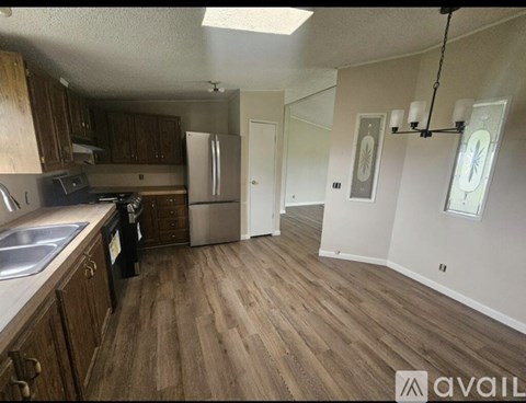 A kitchen with wooden cabinets and a stainless steel refrigerator.